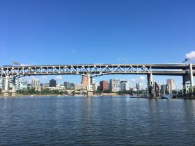 A stunning view of a city skyline with a prominent bridge over the water, showcasing the beauty of urban landscapes from the waterfront.
