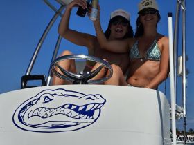 Two friends celebrate on the boat, enjoying drinks and sunshine — a perfect moment for fun on the water.