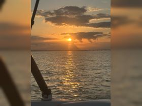 A stunning sunset view over the water, captured from a boat, showcasing the tranquil beauty of evening cruises.