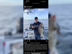 A fisherman proudly displays his catch of a black grouper while out on Lake of Mexico, showcasing the excitement of a successful fishing trip.