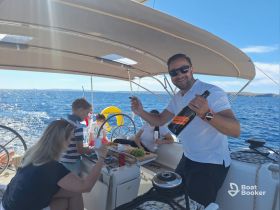 A joyful family celebration aboard a sailboat, featuring delicious food and drinks, perfect for memorable moments on the water.