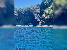 A stunning view of a natural rock arch along the coastline, surrounded by vibrant blue waters — a perfect destination for sightseeing and exploration.
