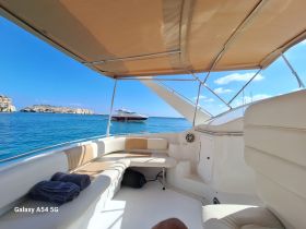 A cozy interior view of a boat's seating area, showcasing a comfortable cabin perfect for relaxation while enjoying the scenic waters.