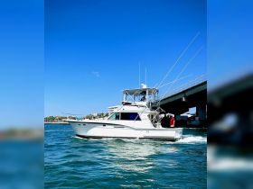 A sleek speedboat navigates through clear waters under a bright blue sky, showcasing its impressive design and perfect for thrilling outings.