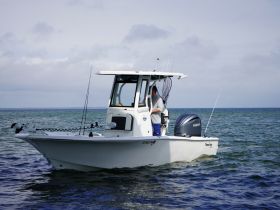 A fisherman prepares for a day on the water aboard a sleek boat, showcasing the perfect setup for an exciting fishing adventure.