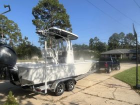 A side view of a sleek center console boat on its trailer, showcasing its design and features, perfect for fishing or leisure outings.