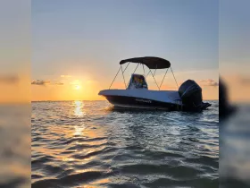 A stunning sunset view of a Wellcraft boat docked on calm waters, showcasing the serene beauty of evening boating.