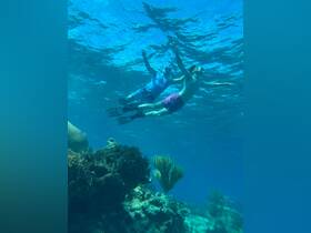 Two snorkelers explore vibrant underwater scenery, showcasing the beauty of marine life and coral formations — a perfect adventure for diving enthusiasts.
