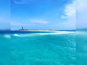 A stunning view of a lighthouse on a picturesque island, surrounded by vibrant turquoise waters — a perfect destination for boating adventures and scenic tours.