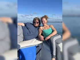 A couple enjoys a relaxing moment on a boat, soaking in the sun and the beautiful water views — perfect for a day out on the water.