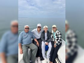 A cheerful family enjoys a day on the water together, capturing a memorable moment aboard their boat.