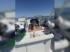 A joyful moment on a boat, showcasing a collection of seashells while enjoying a sunny day on the water.