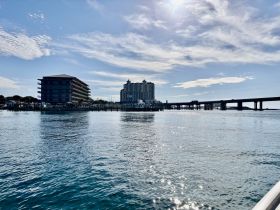 A scenic view of waterfront buildings and a pier under a clear sky, showcasing the tranquil atmosphere of the area.