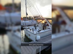 A fishing boat named 'Reel On' docked at sunset, showcasing its fishing gear and spacious seating — perfect for a day out on the water.