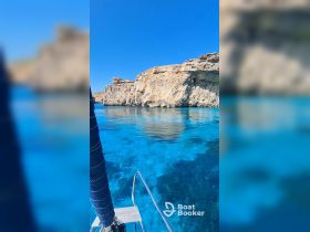 A stunning view of a rocky coastline with crystal-clear waters, perfect for exploring and enjoying the beauty of nature while boating.