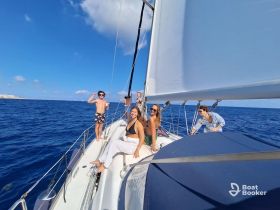 A lively group of friends enjoys a sailing adventure on a beautiful day at sea, capturing the essence of fun and camaraderie on the water.