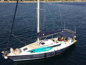 Aerial view of a sailboat docked in calm waters, showcasing its sleek design and spacious deck, perfect for leisurely sailing adventures.