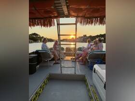 A group of friends enjoys cocktails on a pontoon boat at sunset, creating a perfect atmosphere for relaxation and celebration on the water.