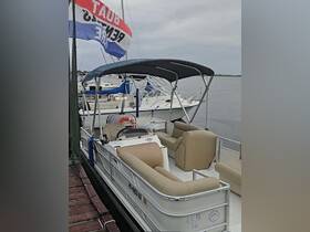 A cozy interior view of a pontoon boat featuring comfortable seating and a helm, perfect for leisurely outings on the water.