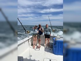 A group of friends enjoys a fishing trip on the open ocean, capturing the excitement of a day on the water.