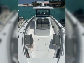 A spacious interior view of a boat's helm and seating area, showcasing comfortable seating and a clean layout, perfect for fishing or day trips.