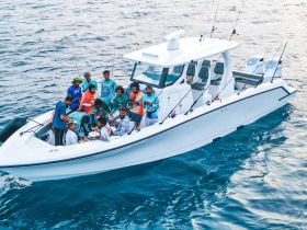 A lively group enjoys a fishing trip aboard a boat, sharing food and laughter on the open ocean — perfect for creating unforgettable memories with friends.
