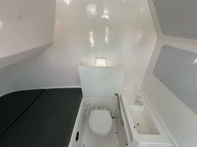 Interior view of a boat's bathroom, showcasing a clean and functional design ideal for comfort during trips at sea.