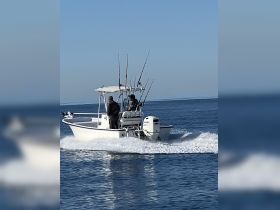 A fishing boat speeds across calm waters, showcasing an exciting day on the water for anglers. Perfect for fishing enthusiasts looking for adventure.