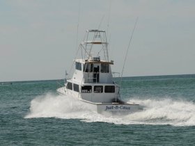 A striking view of the 'Just-B-Cause' boat cutting through the waves, showcasing its sleek design and speed on the open water.