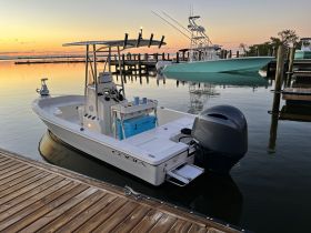 A sleek Cobia speedboat docked at sunset, reflecting the vibrant colors of the sky on calm waters — perfect for fishing or leisurely cruises.
