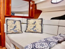 Cozy interior seating area of a boat featuring decorative pillows and a stylish throw, perfect for relaxing during a voyage.