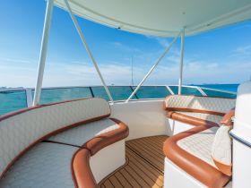 A stylish interior seating area on a boat, featuring comfortable cushions and a panoramic view of the ocean, perfect for relaxing while cruising.