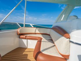 A stylish seating area inside a boat, featuring elegant upholstery and a panoramic view of the ocean — perfect for relaxing while cruising.