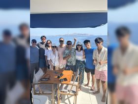 A cheerful group poses for a photo on a boat, enjoying a day of fishing and fun in the sun — perfect for creating lasting memories on the water.