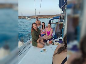 A lively group enjoys a meal on the deck of a boat, creating memorable moments together amidst beautiful waters — perfect for social gatherings and celebrations.