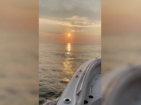 A serene sunset view from the side of a boat, reflecting golden hues on calm waters — perfect for peaceful evening cruises.