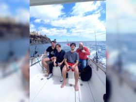 A group of friends enjoys a fishing trip on a boat, capturing the joy of camaraderie and adventure on the open ocean.