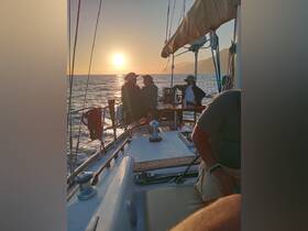A group enjoys a picturesque sunset aboard a sailboat, creating a perfect atmosphere for celebration and relaxation on the water.
