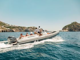 A lively group enjoys a thrilling ride on a speedboat, cruising along a picturesque coastline — perfect for adventure seekers and group outings.