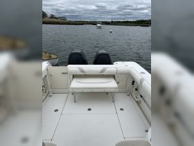 Interior view of a boat showcasing comfortable seating and helm area, perfect for relaxing while on the water.
