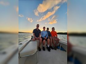 A family enjoys a beautiful sunset on a boat, capturing a memorable moment together on the water.