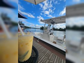 A cozy view of the boat's helm and seating area, complemented by a refreshing drink, perfect for enjoying a day on the water.