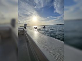 A group enjoys a sunset swim in calm waters, creating a perfect backdrop for memorable beach experiences.
