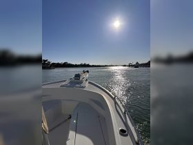 A stunning view from the front of a boat, gliding through calm waters under a bright sun — perfect for a day of exploration on the water.