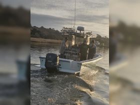 A group of friends enjoys a fishing trip on a boat, showcasing camaraderie and excitement on the water.