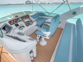 A well-designed helm area of a boat featuring modern controls and comfortable seating, perfect for navigating the beautiful turquoise waters.