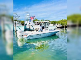 A Sea Hunt boat is docked with a captain at the helm, showcasing its sleek design and readiness for adventure on the water.