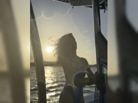 A silhouette of a woman on a boat during sunset, capturing the essence of a serene evening on the water.