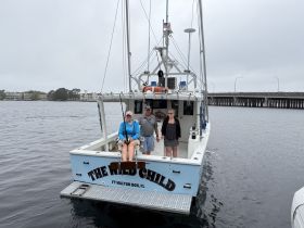 A family enjoys a fishing trip aboard 'The Wild Call' in Fort Walton Beach, capturing the essence of a fun day on the water.