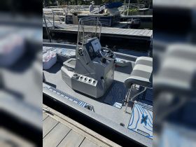 A detailed view of the helm and seating area inside a boat, showcasing the modern console and design elements — perfect for navigating the waters.
